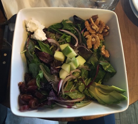 The Harvest contains mixed greens, apples, walnuts, dates, goat cheese, avocado, red onion, and cider vinaigrette