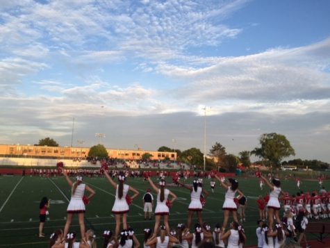The cheerleaders stunt on the sideline to mark the kickoff of the first football game on Aug. 29