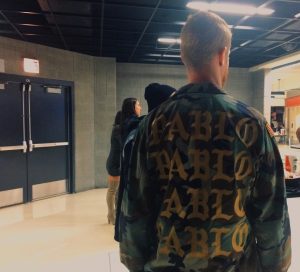 One of West's fans models a camouflage army jacket with "Pablo" written across the back in gold font at the United Center.